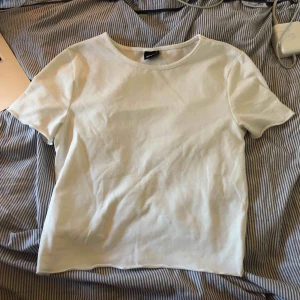  - Snygg t-shirt med lite vågiga ändar på armarna och på nedre delen av tröjan. Säljer på grund av att den är för liten (obs liten i storleken så kan passa en XS) 