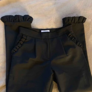  - Jättefina kostymbyxor med volanger ned till och vid fickorna i fram, storlek S. Använda men i nyskick. Köparen står för eventuell fraktkostnad. 