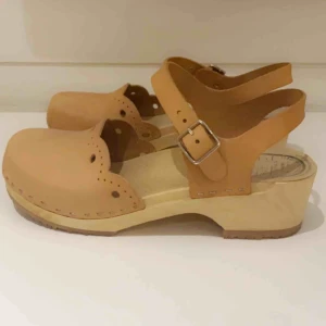  - Träskor i strl 38 äkta skinn men en fin naturfärgad nyans. Skorna är i mycket gott skick eftersom de knappt är använda. Nypris 760:- Säljer de nu för 400:-Skorna är otroligt bekväma och de passar perfekt nu till sommaren! Köparen står för frakt 