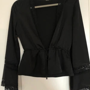 Satinblus med spetsdetaljer  - Fin blus i satin med spetsdetaljer, endast använd enstaka gång. Som ny. Storlek XS