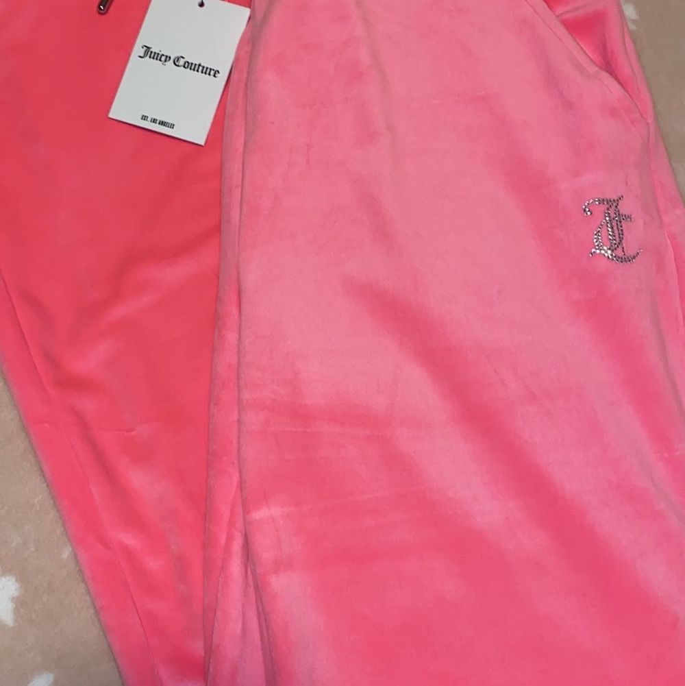 Säljer nu dessa två par Juicy Couture mjukis byxorna. Byxorna är aldrig använda & båda har prislappen kvar, anledningen till varför jag säljer de är för att jag inte haft tiden till att lämna tillbaka dom. Datumet för returen hade gått ut. Byxorna är inte i min storlek och därmed kan någon annan få en användning utav de. Båda byxorna är i storlek (L) Byxorna är i två olika modeller som ni kan se på bilderna. De ljusrosa har resårband i ändarna av byxorna samt fickor men även resårband i midjan. De mörk rosa byxorna är en mer ”vanlig” modell och är utsvängda byxor med vanlig knytning i midjan. Båda byxorna har Juicy couture märket i diamanter på bakdelen. Byxorna är köpta för 1000kr styck & säljs för 700 ( priset kan diskuteras vid snabb affär). Jeans & Byxor.