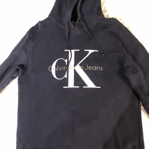 Marinblå Calvin Klein hoodie - Marinblå Calvin Klein hoodie i bra skick, Strl L (herr storlek) Pris: 300 kr eller högstbjudande. Köparen står för frakten, fraktkostnaden är ett ungefärligt pris