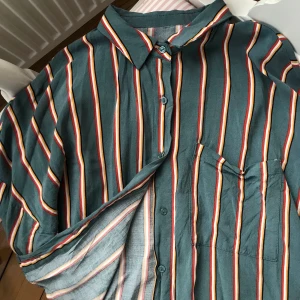 Skjortblus, vintagestil  - Tunn skjorta från Bershka. Slutar lite under naveln så är perfekt att stoppa in i byxor. 