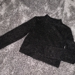 Glitter tröja - En fin svart tröja med silvergnistrande i.