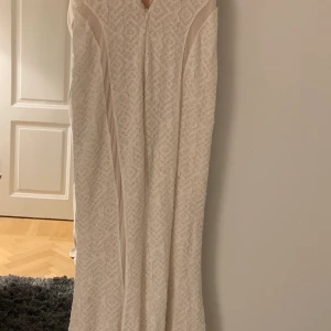 Klänning - En vit  Guess klänning, den  är vit/Beige. I storlek M 