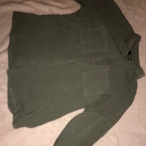 Militärgrön skjorta  - Militärgrön skjorta med knappar och lite lösare passform 