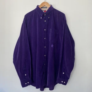 Tommy Hilfiger skjorta - Snygg Tommy Hilfiger skjorta i manchesterstyg! Dom två första bilderna visar färgen rättvisast, skjortan är lila. 