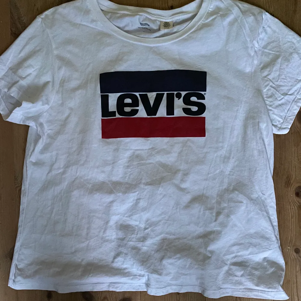 Vit T-shirt från Levi’s som är använd fåtal gånger. Bra skick. Storlek XL (passar mindre storlekar). 100% bomull. Första bilden är lånad. Nypris 299kr. Säljer för 145kr + frakt 🤍. T-shirts.
