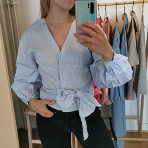 Ljusblå blus  - Ljusblå blus med röda ränder. Bra skick 