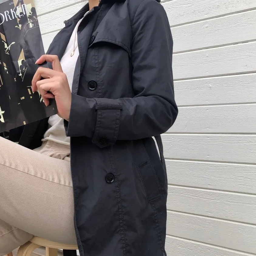 Sparsamt använd trench coat från Banana Republic i mörkgrå. En inneficka, två ytterfickor samt medhörande skärp. Vattenresistent yttermaterial i bomull och polyester. Strl. XS och normal i passformen. Ordinarie pris: 2589 kr. Modellen är 164 cm. . Jackor.