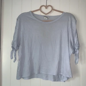 Babyblå somrig topp - En somrig pastellblå T-shirt från monki med knytdetaljer på ärmarna