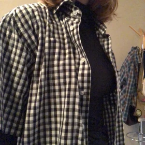 Rutig kortärmad skjorta - Svartvit rutig kortärmad skjorta köpt second hand men i perfelt skick! Går att kombinera på många sätt :) bara att skriva ifall du har några frågor