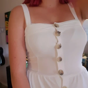 Vit jumpsuit m. knappar - Säljer denna då den var för liten när jag köpte den. Så den är bara använd ett fåtal gånger. Det är en jumpsuit med shorts och väldigt bekväm till sommarn. Storlek S