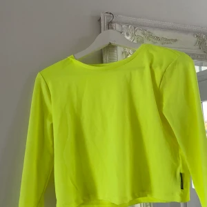 Cool neontröja från crooked tongues - En supercool croppad neongul tröja från crooked tongues!! 🌟 perfekt till temafest eller bara för att skapa en svincool outfit. Strl M. Säljer för 100 kr inklusive frakt