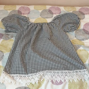 Svart off shoulder topp med stora rutor - En topp som är off shoulder. Med stora svar vita rutar på.