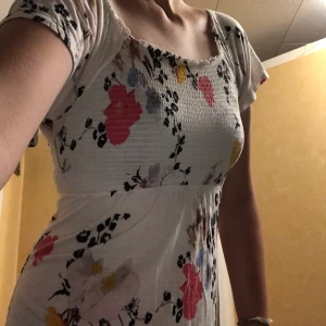 Vit klänning H&M strl S - Vit klänning med blommönster, resår på bystområdet. Väldigt gullig med fladdriga ärmar💕 Lite kort för mig tyvärr, men kan had som tunika också (frakt ingår ej)