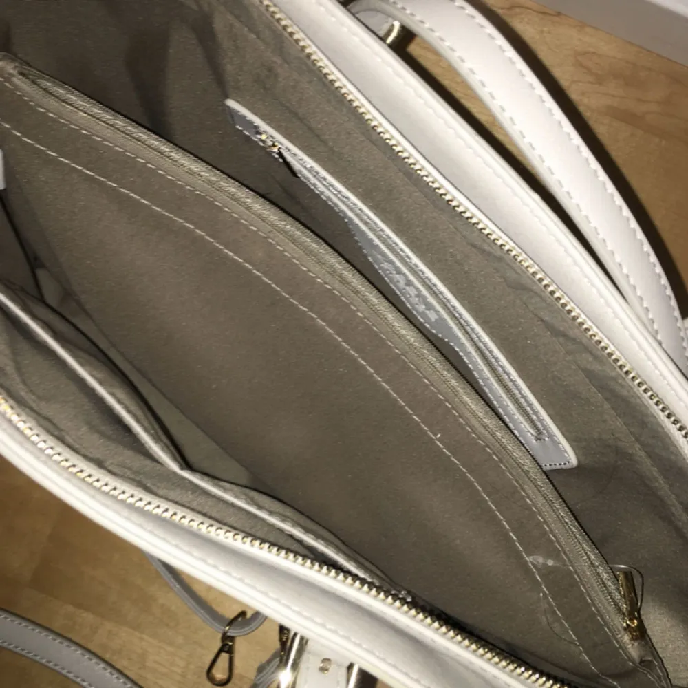 Skitsnygg gråbeige handväska. Helt oanvänd men stått i min garderob i några år. Säljer p.g.a att jag inte använder handväskor. Frakten tillkommer. Axelband (eller vad det heter) finns, avtagbar.. Väskor.