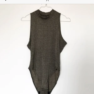  - Guld-glittrig body i super skick  Använd 1 gång Fraktavgift tillkommer (fraktfritt: jag möter upp i Malmö) Skickar gärna fler bilder!  