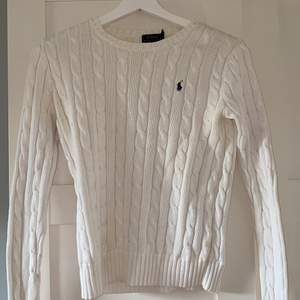 Säljer denna vita kabelstickade tröjan från Polo Ralph Lauren. Använd en del men är i bra skick. Köparen står för frakten!