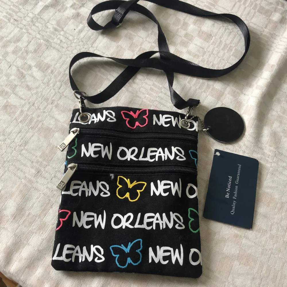 Svart väska med ”New Orleans” på. Oanvänd och har lapp kvar. Ca 15 x 10 cm. . Väskor.