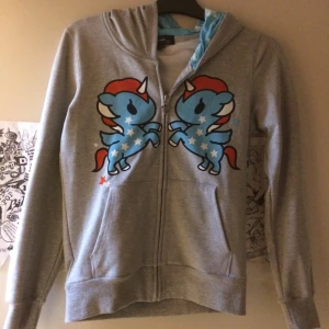 Tokidoki hoodie   - Grå hoodie med TokiDoki print samt en stjärna på baksidan. Hela luvan är full av blå färg (ska vara så). Storlek M. Oanvänd. Priset är inkl vanlig frakt. 