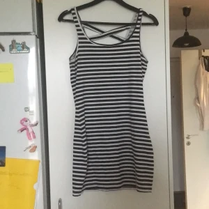 Randig klänning stl s - Svart och vit klänning med kryss i ryggen. 