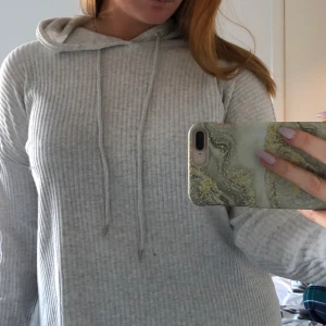 Ribbad luvtröja - Väldigt tunn luvtröja som är ribbad i materialet. Använd fåtal tillfällen men i gott skick. Skriv gärna för bättre bilder eller mer information.