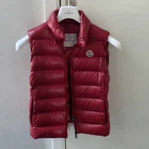 Moncler väst intressekoll - Röd moncler väst. Modell: Ghany, köpt på NK. Sparsamt använd. Intressekoll! Älskar den mörkare röda färgen! Passar xs/s. Endast seriösa bud! FINNS INGA SKADOR ELLER DEFEKTER DÅ JAG INTE HAR ANVÄNT DEN MYCKET O DEN FÖR DET MESTA HAR HÄNGT I GADEROBEN. 