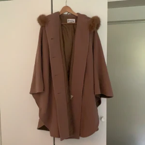 Kappa säljes - Lång kappa i luftig form med luva och äkta päls.