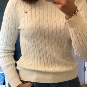 Kabelstickad tröja Gant - En vit kabelstickad tröja från Gant. Tröjan är i väldigt bra skick. Jag skulle säga att den är i XS då armarna är lite för korta för mig och jag har vanligtvis S. Frakt ingår inte