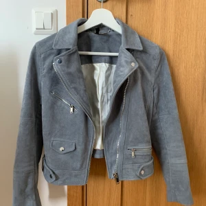 Grå/blå jacka från H&M (premium) - ”Mocka”jacka från H&M som var från en Premium kollektion (originalpris 699kr). Använt ett par gånger. Storlek 34 (divided). Frakt tillkommer!