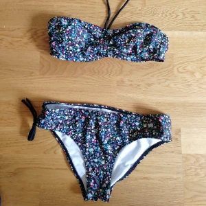Bikini - Blommig bikini. Storlekslapp sitter ej kvar. Tippar att den passar en xs. Jag använder vanligtvis S eller M och denna sitter ordentligt slimmat på mig, inte smärtsamt slimmat dock. Frakt tillkommer