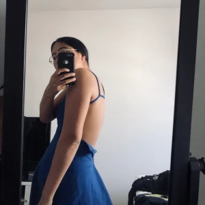 Klänning öppen rygg - En jättefin blå klänning från Nelly. Köpt för flera år sedan. Skönt tjockt tyg och i fint skick! Har dragkedjan öppen på bilderna pga för liten i midjan för mig. Frakt tillkommer om den ska skickas!