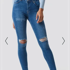 Jeans  - Säljer mina blåa Jeans med hål på knäna från nakd, knappt använda. Dom är högmidjade.
