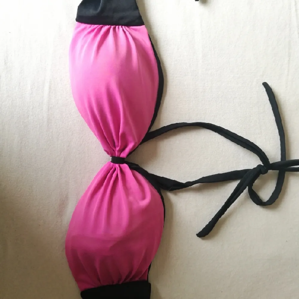 A nice swimsuit, bra has a double face (black with a small pink strip and a pink face with a small black band). Accessoarer.