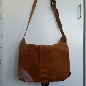  - 24 cm hög × 34 bred läderväska med innerficka. Något sliten med en fläck på baksidan men fortfarande en pärla! Måste säljas pga flytt. Möts gärna upp i sthlm city. ;D 