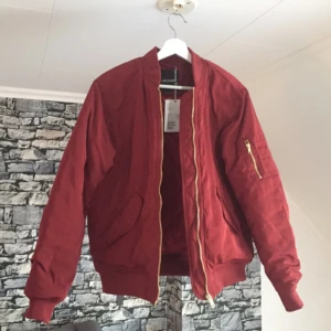  - Helt ny bomberjacka i oversize modell från Monki. Snyggt röd med guld detaljer.