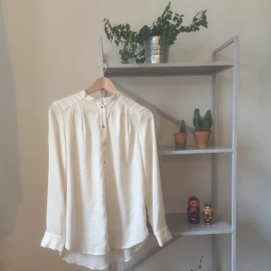  - Benvit blus i strl 34 men den passar mig fint som är i strl 36/38. Använd med omsorg och inte mycket slitage. Sprättat bort ett svart band som fanns på kragen, något synliga hål från tråden om en kollar riiiiiktigt nära.