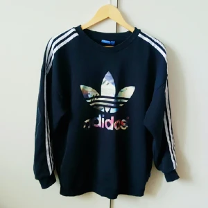  - Sweatshirt från Adidas med färgglatt tryck. Betalning sker via swish och köparen står för frakten 💃