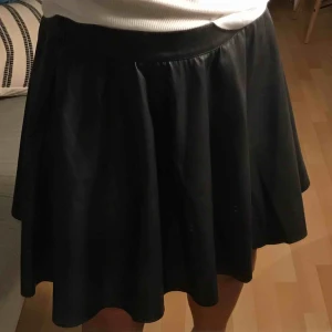  - Svart fakeläderkjol. Jätteskönt material. Från vila. Frakt tillkommer. 