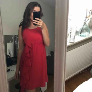  - En röd klänning med en volang i bra skick. Köparen står för frakten:)