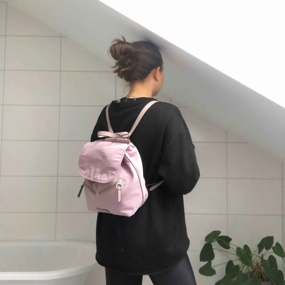 En skitsnygg pastellrosa ryggsäck från Parfois med många smarta fack och fickor. Får plats med mycket men ändå en liten väska. . Väskor.