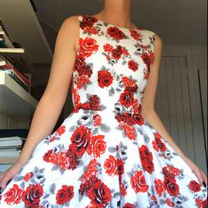 Kort klänning i 50-talsmodell. Bomullssatin med djupt röda rosor på. Båtringning i halsen och klockad kjol. Köparen står för frakt eller möts i Gbg ✨