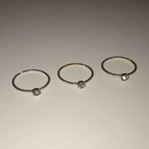  - 3 likadana guld ringar med en glittrig sten. Väldigt enkla och basic fina! Använda endast 1 gång, fint skick. 