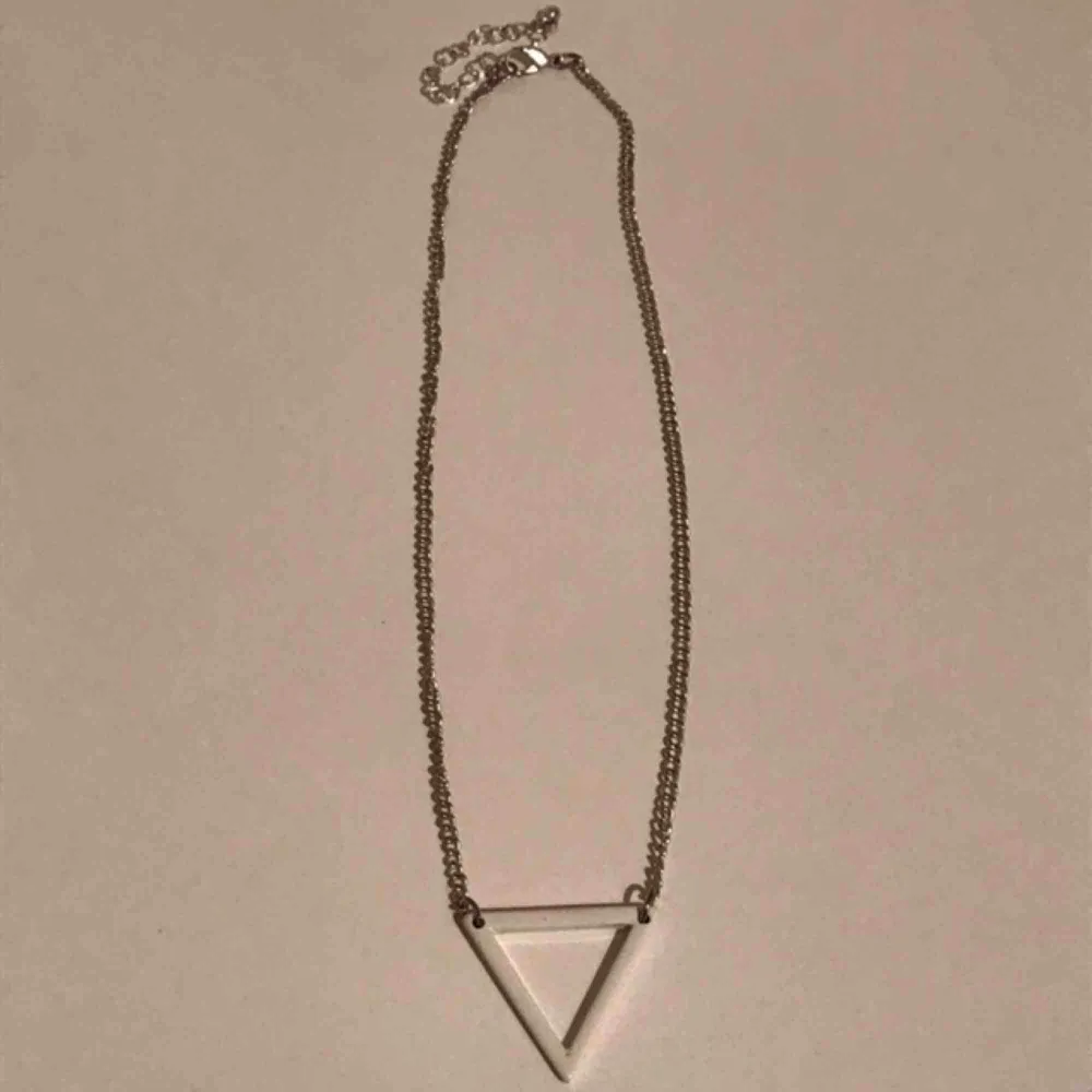 Snyggt och enkelt silver halsband med vit triangel. Fint skick. Justerbar kedja. . Accessoarer.