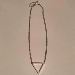 - Snyggt och enkelt silver halsband med vit triangel. Fint skick. Justerbar kedja. 