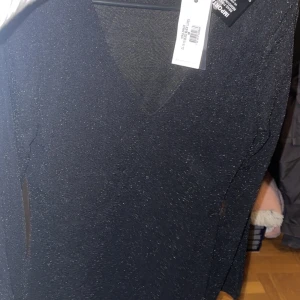 Svart glittrig klänning  - Storlek M & helt ny med lappar kvar. Vida armar & slits på armen 