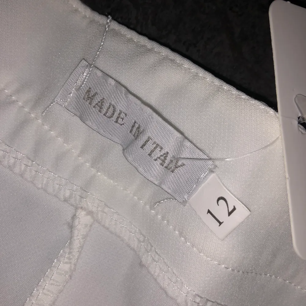 Helt oanvända vita kostymbyxor som har prislappen kvar. Storlek 12 som motsvar M/L. Jeans & Byxor.