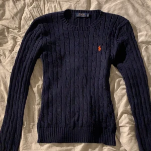 Polo Ralph Lauren tröja i Marinblå strl M - Marinblå ribbstickad tröja i bomull. Rund uringning. Sparsamt använd. Riktigt fin kvalite! Passar perfekt nu när det är kallare ute:) Strl M