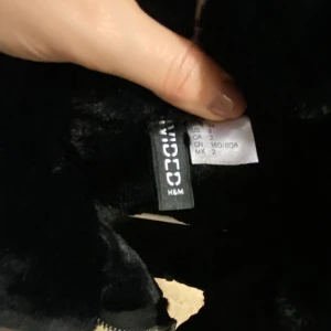 Fejk mocka jacka i svart och fuskpäls - Otroligt fin och stilren fejk mocka jacka i svart med en väldigt mjuk fuskpäls, den är så himla fin och aldrig använd. Den passar otroligt bra i dessa tider, köp den och garantera din vinter.